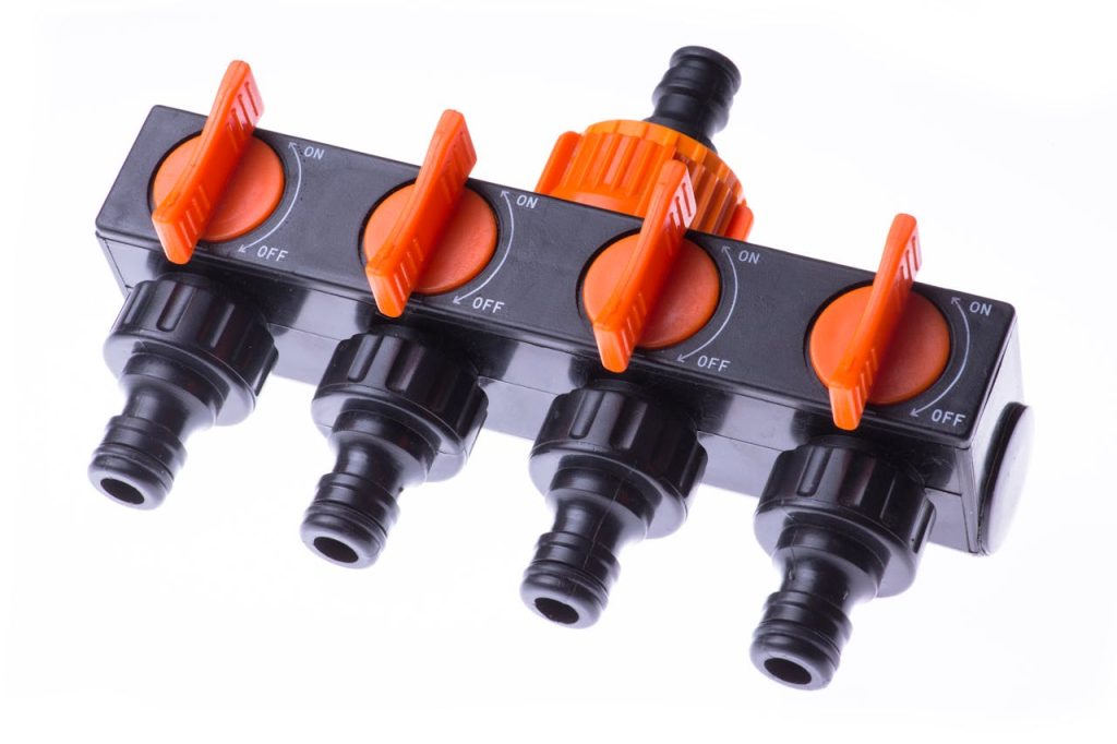 A multi-channel garden hose valve manifold with orange control levers for effective irrigation.